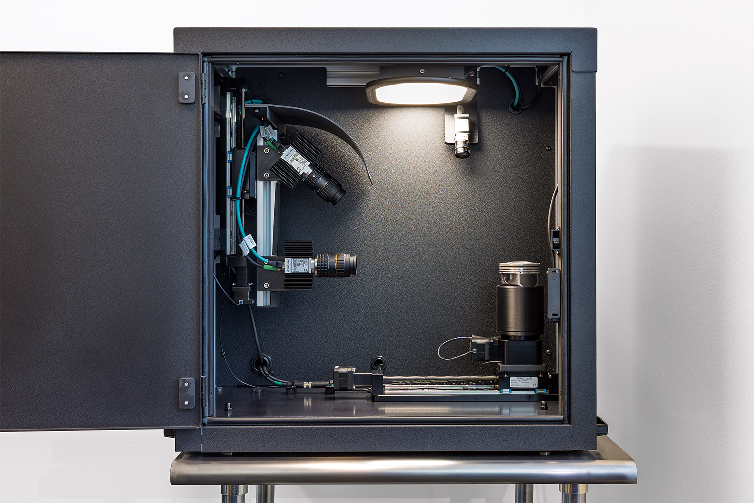 Interior of Rapta Precision Inspection showing multi-axis cameras, controlled lighting, and a rotary inspection stage